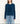a woman wearing a brushed yarn crewneck sweater in a deep blue and blue jeans on a white background.