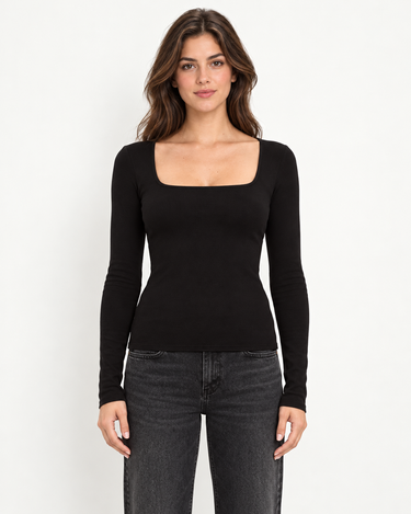 A woman wearing a black square neck long sleeve top and black jeans on a white background