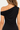A close up on the back drape detailing of the a black off shoulder top on a white background.
