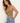a woman wearing a cocoa shine crop tank with ruched side detailing on a white background