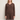 A woman wearing a knit v neck brown sweater and brown knit pants on a white background