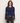 A woman wearing a navy cropped long sleeve and black jeans on a white background