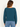 A woman wearing a teal ribbed long sleeve top and blue jeans on a white background.