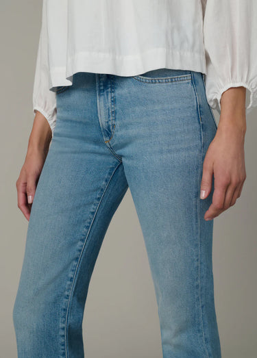 A woman wearing light blue high rise jeans