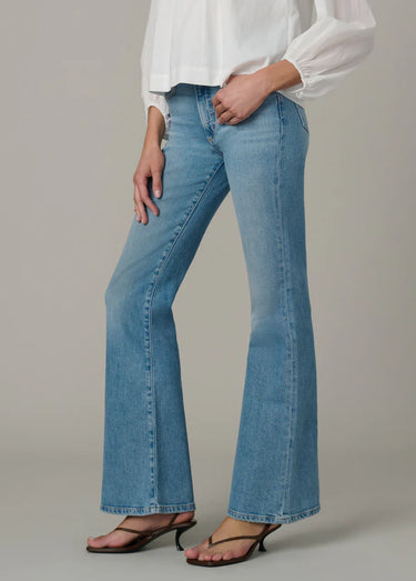 A woman wearing high rise flare blue jeans
