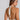 Woman wearing a white halter top with thin straps on a plain background