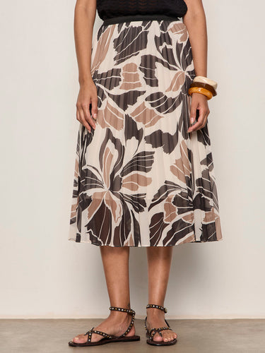 Person wearing a patterned skirt with a plain background