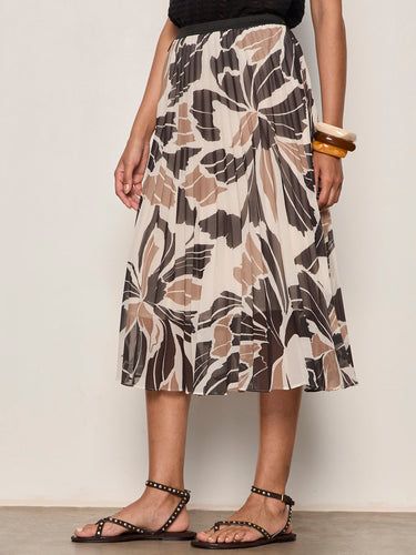 Person wearing a patterned skirt with a plain background