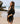 A woman on the beach wearing a tie front black tunic with a back lace panel