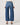 Person wearing blue jeans on a plain background
