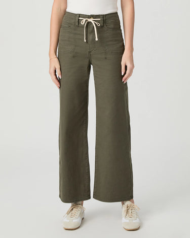 A model wearing olive green wide-leg cropped pants with a cream drawstring waist, paired with a white top and white sneakers, against a light gray studio background.
