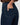 Close-up of a person wearing dark blue denim jeans, showing the back pocket and hand in the pocket.