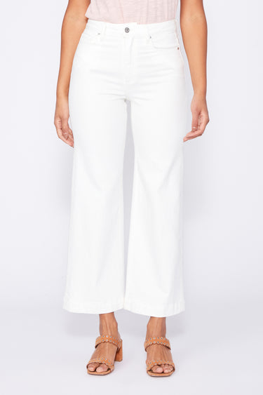 Person wearing white wide-leg, ankle length pants on a plain background
