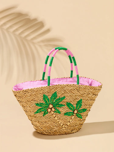 Woven basket with pink interior and green palm tree designs on a beige background