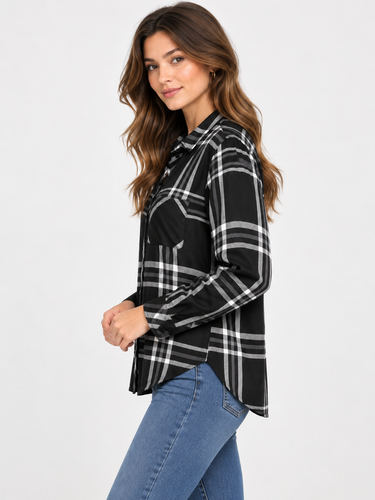 a woman wearing a black and ivory plaid collared shirt and blue jeans on a white background.