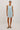 Woman wearing a light blue denim dress on a white background