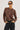 Person wearing a leopard print sweater and black pants on a plain background
