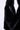 Close-up of a black faux fur bag with a black leather zipper detail, set against a plain white background.