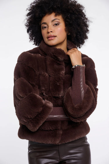 Woman wearing a brown fur coat against a white background