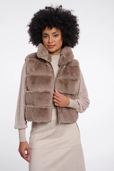 Woman wearing a brown faux fur vest on a white background