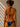 Woman wearing a navy blue bikini against a beige wall.