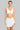 Woman wearing a white sleeveless top and skirt on a white background