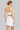Woman wearing a white sports bra and skirt set on a white background