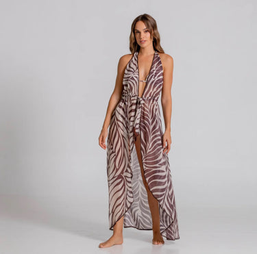 Woman wearing a zebra print halter neck dress on a plain background