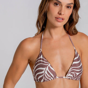 Woman wearing a zebra print bikini top against a plain background