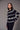 Black and white Fair Isle patterned sweater styled with slim black pants and black heels on a model.