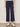 A woman wearing navy blue cropped pants on a neutral background