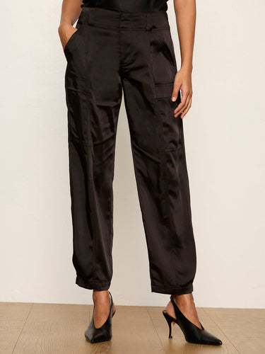 Black wide-leg trousers with a satin-like sheen, shown on a model wearing black slingback heels against a neutral studio background.