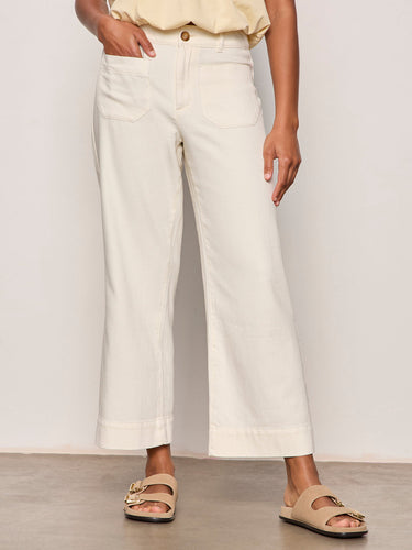 a woman wearing wide leg off white pants on a neutral background