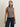 Model wearing a navy and ivory striped sleeveless knit sweater with navy pinstripe wide-leg pants.
