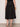 Person wearing a black skirt against a plain background