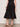 Person wearing a black skirt against a plain background