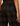 Close-up back view of a person wearing dark brown and black plaid trousers, showing the fabric texture and back pocket detail.