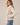 A woman wearing a multi textured jacket with fuzzy and ribbed textures on a white background.