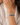 A close-up of a person's wrist wearing a multi-strand beaded bracelet with blue, white, and pink beads, styled with a white blouse.