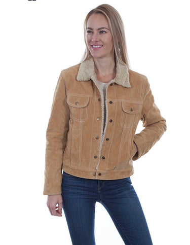A woman wearing a tan suede jacket with a cream sherpa collar, paired with dark blue jeans, photographed against a plain white background.