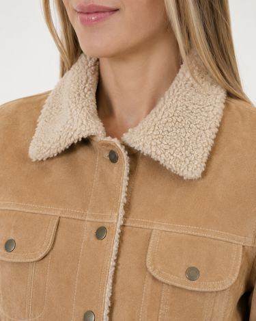 Close-up of a woman wearing a tan suede jacket with a thick cream sherpa fleece collar and matching trim.