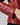 A woman wearing a soft red leather jacket and we see a close up of the sleeve with button detailing