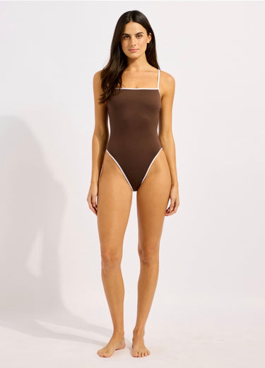 Woman wearing a brown one-piece swimsuit on a white background