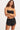 A woman wearing a bikini top and black shorts