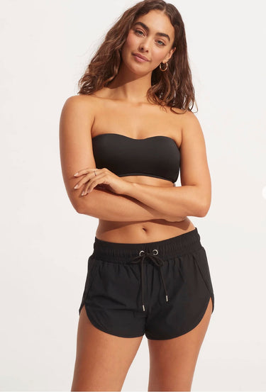 A woman wearing a bikini top and black shorts