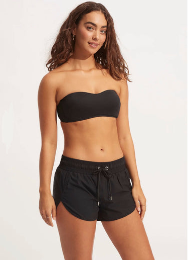 A woman wearing a bikini top and black shorts