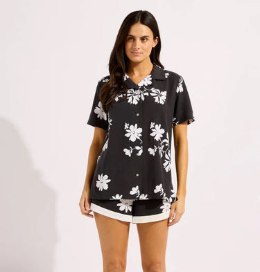 a Hawaiian black button up shirt on a model on a neutral background