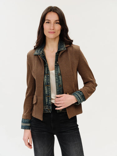 a woman wearing a mixed media jacket, which consists of a denim jacket and brown checkered blazer on a white background.