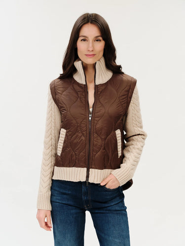 a woman wearing a mixed media jacket that consists of a brown vest and knit sleeves and collar on the jacket.