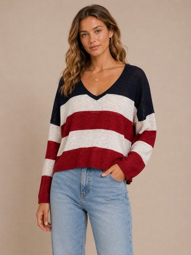 Woman wearing a patriotic striped sweater and jeans against a beige background